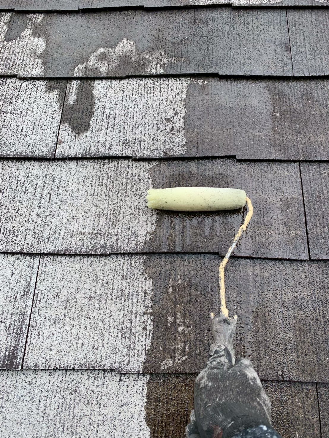 屋根下塗り。屋根材へ下塗りしている場面です。塗料名は確認中です。